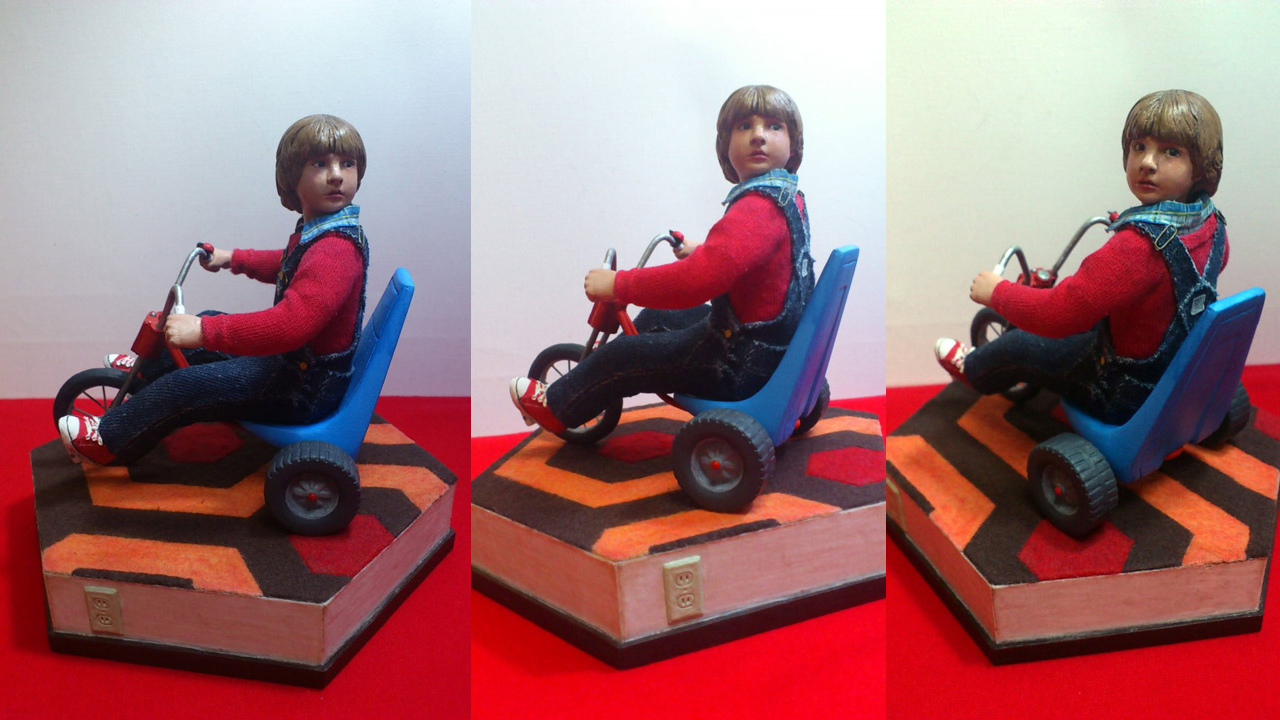 Three images side by side by side in full body shots of the completed miniature statue of Danny Torrance in various angles on base