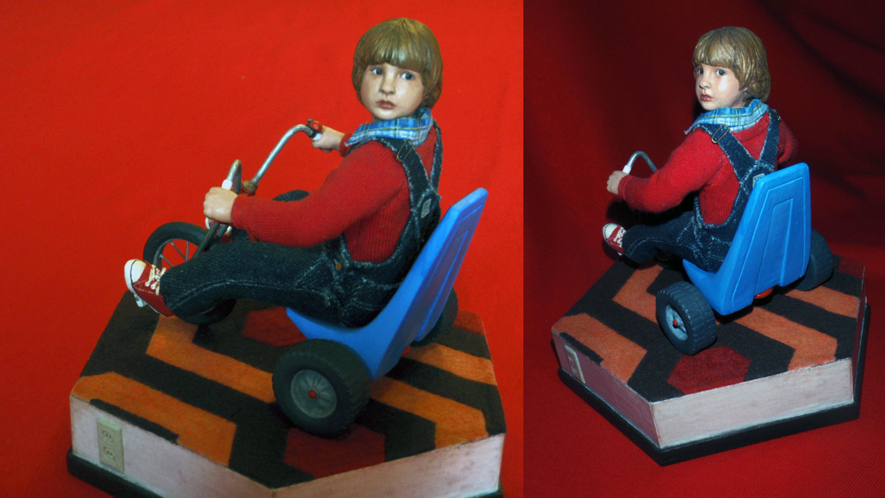 Two images side by side in full body shots of the completed miniature statue of Danny Torrance with red background