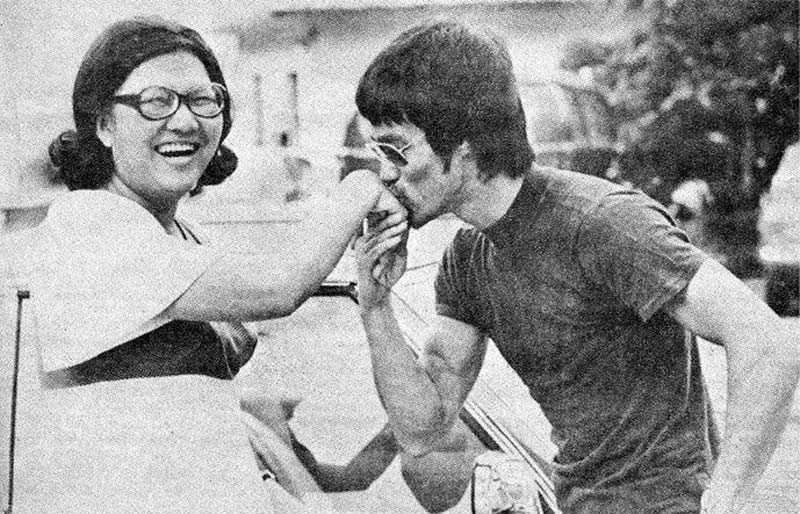 Black and white photo of the Master Bruce Lee kissing the hand of a very lucky fan