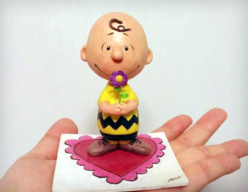 Charlie Brown from The Peanuts holding a purple flower standing on a Valentine's heart theme base statue by Marten Go aka MGO in his palm