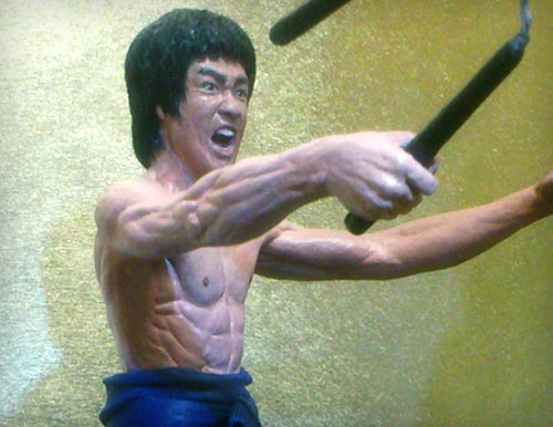 Bruce Lee as Mr. LEE in the martial arts classic Enter the Dragon with one hand out and other clutching nunchaku in attack motion statue by Marten Go aka MGO